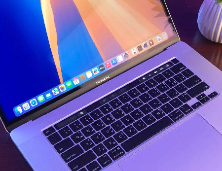Close-up of a laptop with a visible brand logo on a desk.